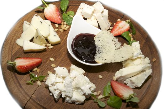 cheese plate with several kinds of cheese sauce and strawberries