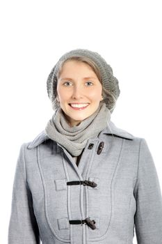 Beautiful smiling woman in a warm, grey winter ensemble wth an overcoat, cap, and scarf isolated on white