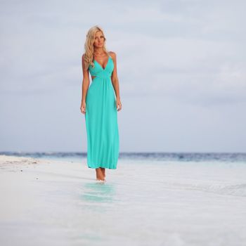 woman in a blue dress on the ocean coast