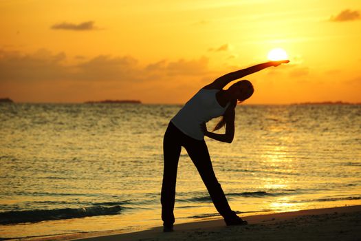 sunset yoga woman on sea coast