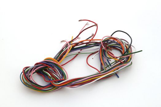 Close up of multicoloured wire against a plain white background.