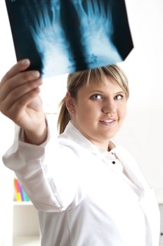 woman doctor looks at x-ray film, smile