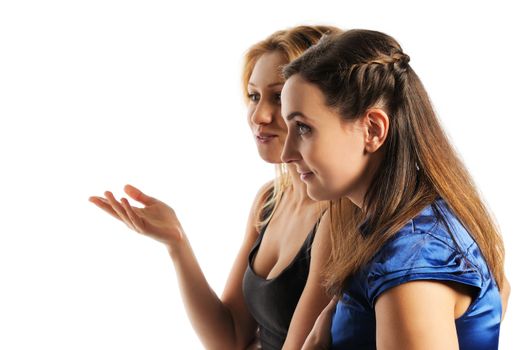 Two young attractive women discussing, look to the left. Isolated on white.