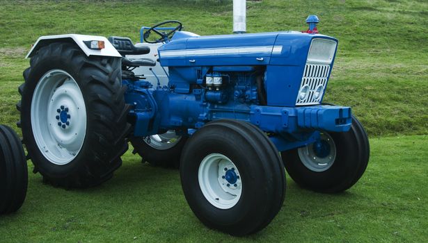 old working tractor on green grass