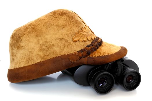 old traditional hunting hat and binoculars on white background