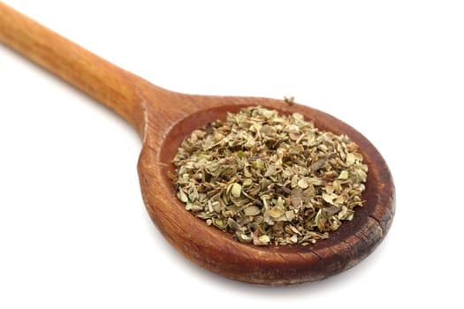 oregano in an old wooden spoon over white background