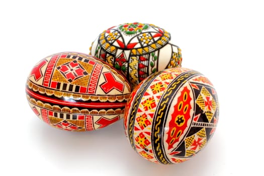 three hand painted eggs over white background