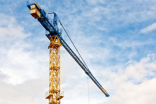 Yellow construction crane on blue sky