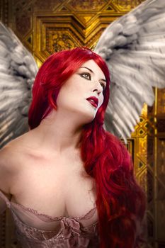 Beautiful gothic sexy angel with wings, red hair over gold background