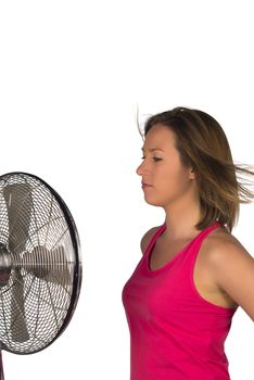 Blond girl standing next to a moving fan