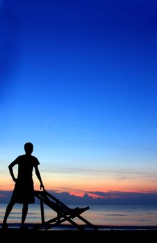 deckchairs and man on beach at sunset