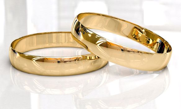 Wedding rings on a light background with reflections.