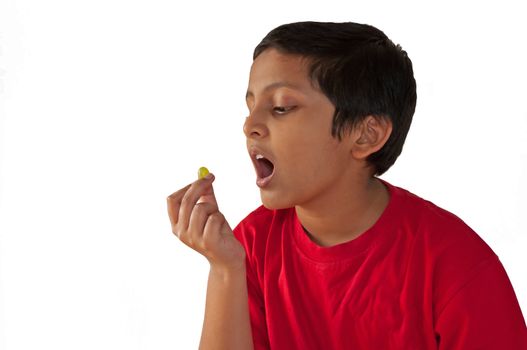 Asian, Indian, Bengali young boy eating grape, open mouth,isolated,white background
