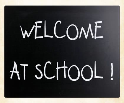"Welcome at school" handwritten with white chalk on a blackboard