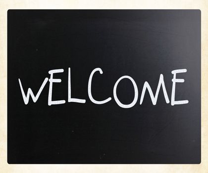 "Welcome" handwritten with white chalk on a blackboard