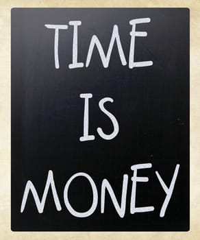 "Time is money" handwritten with white chalk on a blackboard