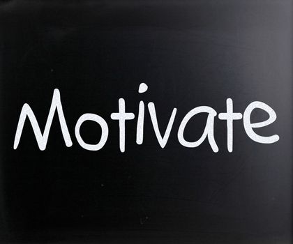 "Motivate" handwritten with white chalk on a blackboard