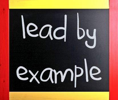 "Lead by example" handwritten with white chalk on a blackboard