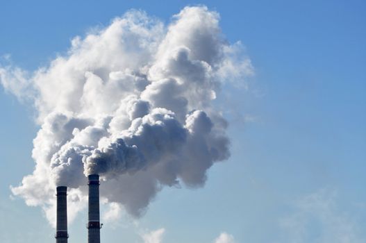 industrial smoke from chimney on blue sky