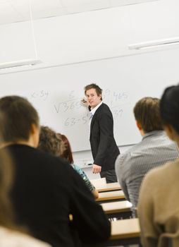 Schoolteacher in front of pupils in the classroom