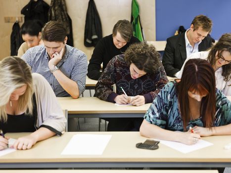 Large group of young adults studying in a classroom