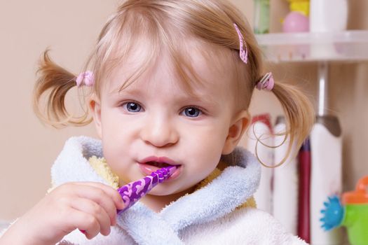 Little girl brushing her teeth in bath