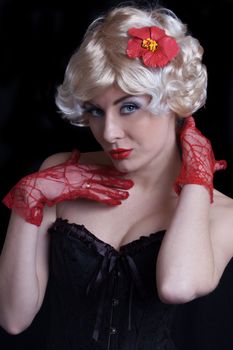 Blond woman in corset with red gloves over black