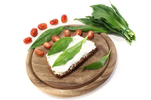 Slice of bread with fresh cottage cheese, ramson and chopped tomatoes