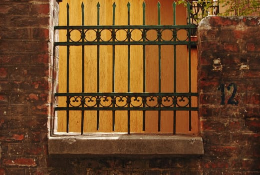 Old iron decorative fence on brick's wall