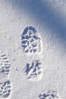 Human boot shoe footprint in clean pure white snow