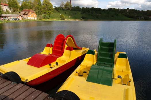 two pedal boats at a small wooden pier