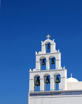 Greek bell tower againgst blue sky background