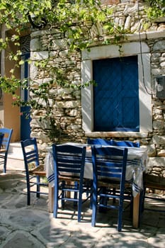 Traditional Greek outdoor tavern table and blue chairs