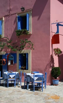 Greek tavern restaurant with traditional blue chairs and tables