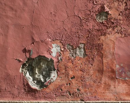 Grungy plaster stone wall with holes and scratches, paint peeling