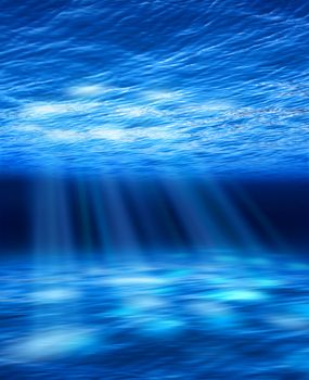 Light beams from ocean surface penetrate underwater through deep blue sea