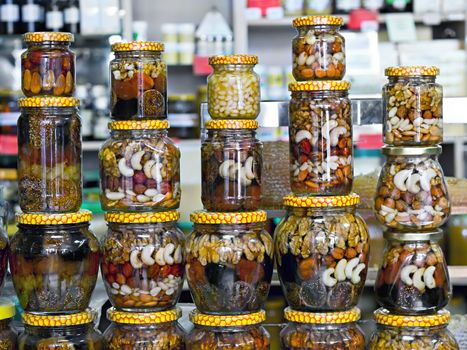 glass jars with nuts and honey on display in a store in the background