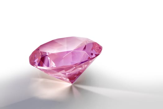 Pink gemstone diamond shining on light grey background