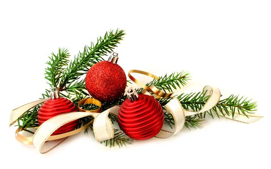 Red Christmas balls, ribbon and green branch on white background