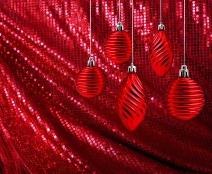 Red Christmas decoration balls and cones hanging on glitter canvas