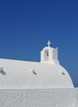 White washed traditional Greek church against blue sky background