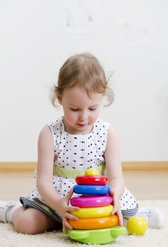 Little girl playing in a pyramid toy
