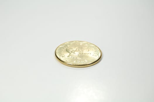 A shiny golden 5-peso coin