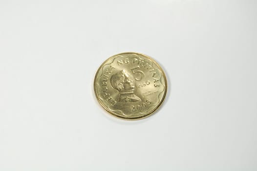 A shiny golden 5-peso coin