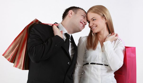 Happy couple with shopping bags against a white background.