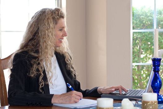 Mature woman on laptop working and typing