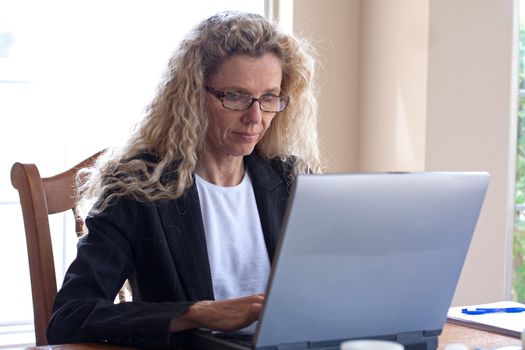 Mature woman on laptop working and typing