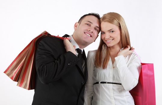 Happy couple with shopping bags against a white background.