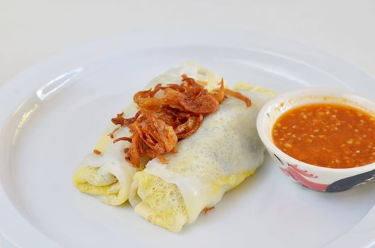 Vietnamese rice noodle rolls with a filling of pork sliced and egg ,  fried onion on white dish