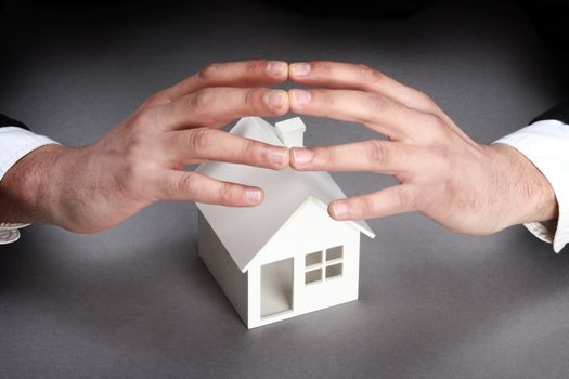 Hands and house model. Real property or insurance concept 